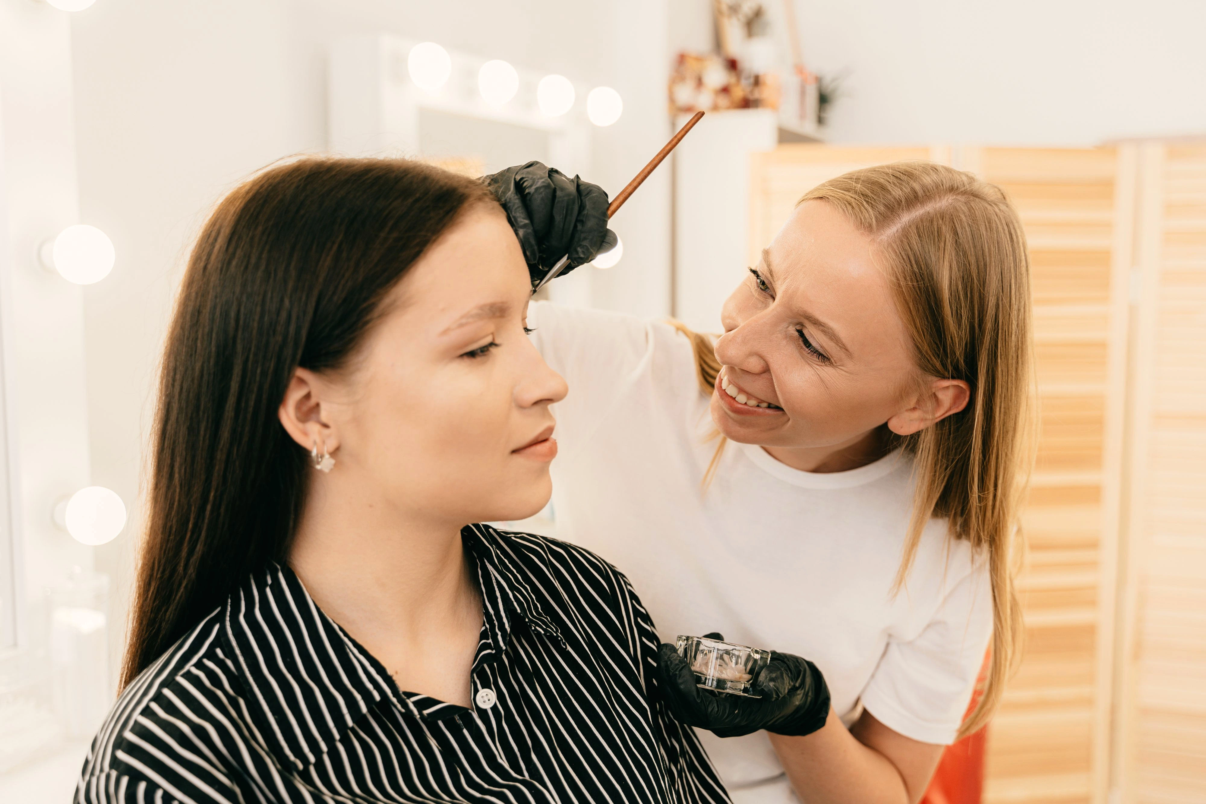 Spokojená klientka píše na telefonu recenzi salonu po návštěvě