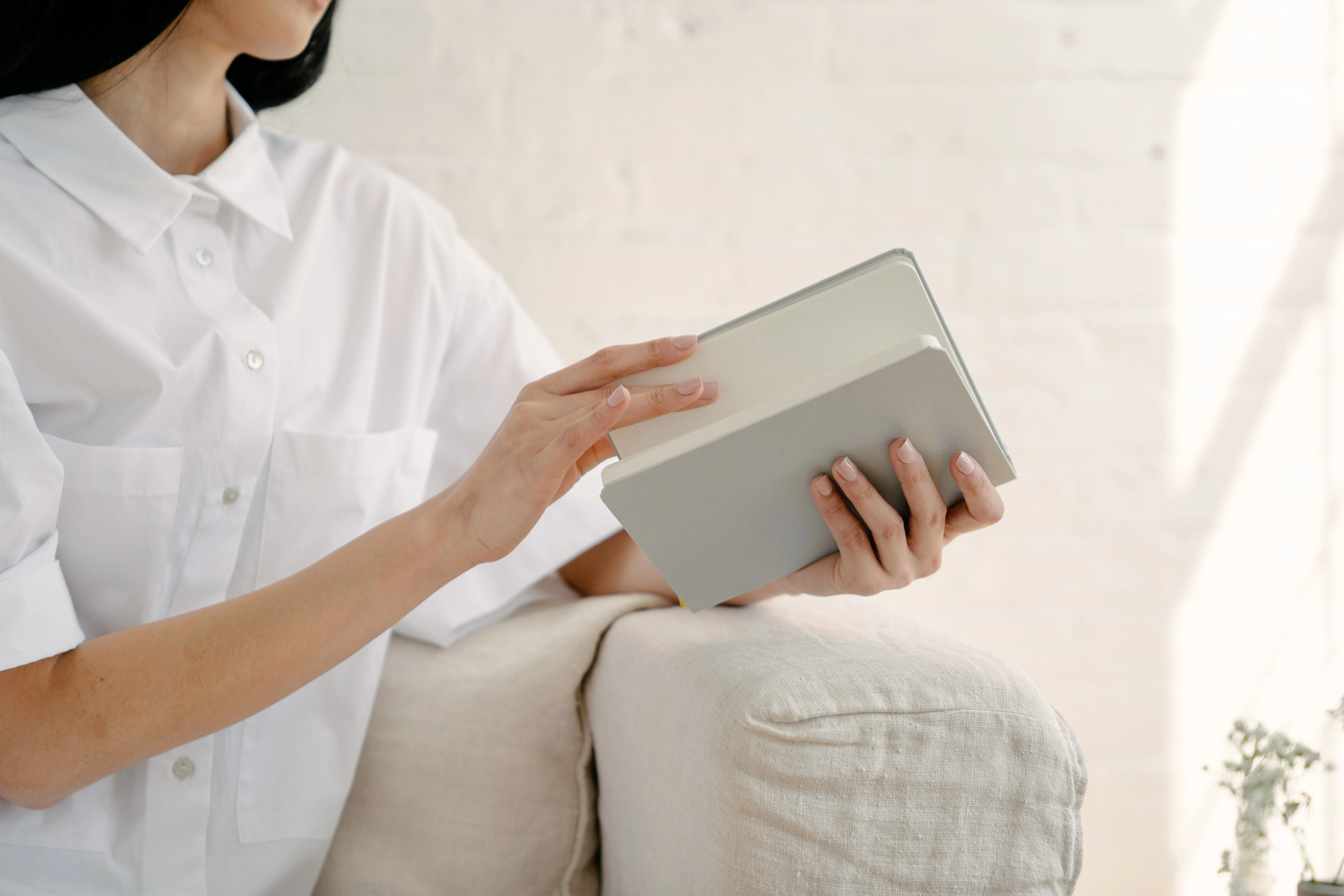 Papírový diář vedle tabletu s digitální klientskou kartou na recepci salonu
